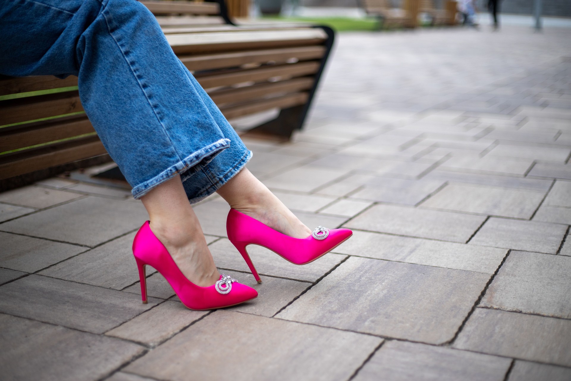close-up of a woman's legs in jeans with bright fuchsia high-heeled shoes on the street close-up of a woman's legs in jeans with bright fuchsia high-heeled shoes on the street